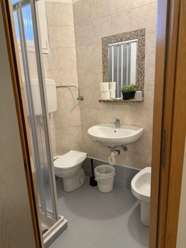 a bathroom with a sink and a toilet and a mirror at Hotel Picador in Rimini