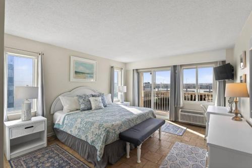 a bedroom with a bed and a balcony at New / Oceanfront Beach Condo, Pool, Gym, Fishing in Virginia Beach