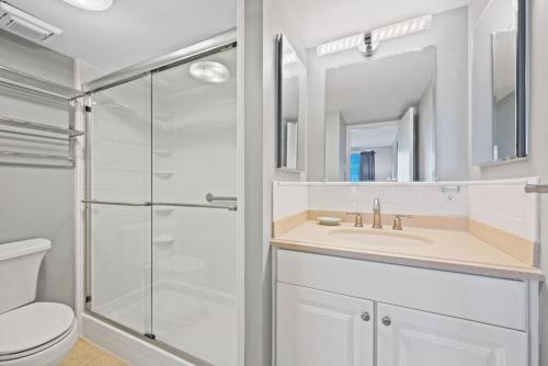 a bathroom with a shower and a toilet and a sink at Oceanfront Condo/ Pool/ Surfing/ Fishing / EW 1002 in Virginia Beach