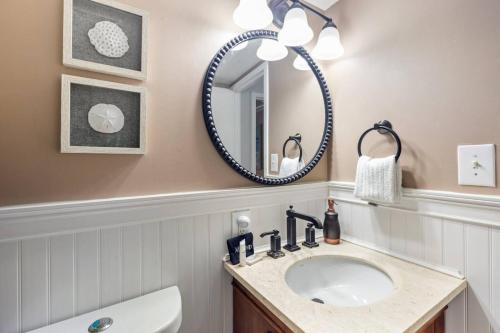 a bathroom with a sink and a mirror at Oceanfront Condo, Heated Pool, Fitness Center in Virginia Beach