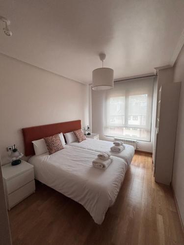 a bedroom with a large bed with two towels on it at Apartamento Oviedo Naranco in Oviedo