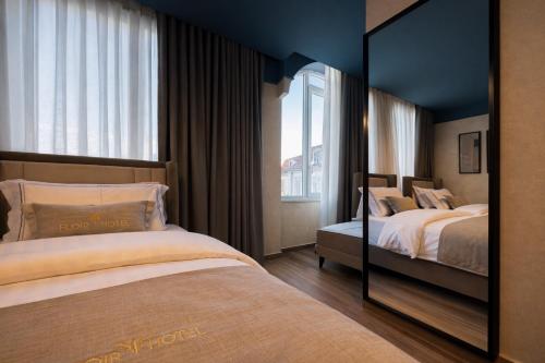 a hotel room with two beds and a mirror at Shkoder City Center - Floir Hotel in Shkodër
