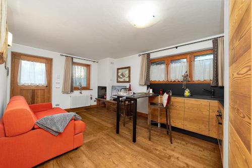 a living room with a red couch and a table at Maison Carrel Elegant 8 in Breuil-Cervinia