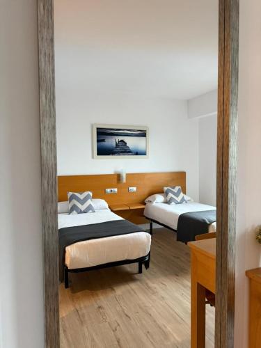 ein Zimmer mit zwei Betten und einem Spiegel in der Unterkunft Hotel Txintxua in Hernani