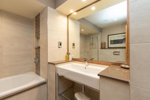 a bathroom with a sink and a bath tub at Underscar - Luxury 3 Bed Apartment in Applethwaite