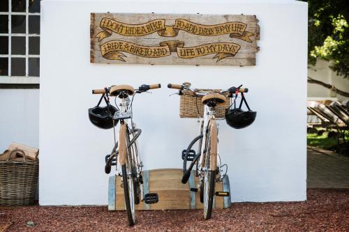 2 biciclette sono parcheggiate accanto a un muro di Akademie Street Boutique Hotel a Franschhoek