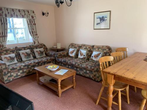 a living room with a couch and a table at The Stable, Magheramore Courtyard in Dungiven