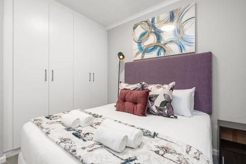 a white bedroom with a large bed with pillows at The Orion 16 in Table View
