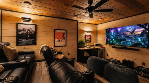 a living room with leather couches and a flat screen tv at Smith Creek Resort - 5 Bedrooms 20 Guest - Indoor Pool - Resort Amenities in Pigeon Forge