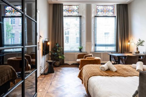 a hotel room with two beds and a table and chairs at City center located City Villa Tilburg Alexander in Tilburg