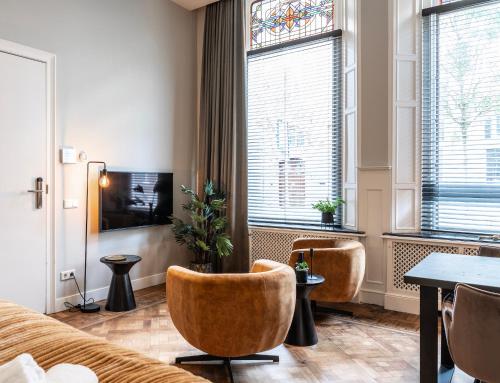 a living room with a couch and chairs and a window at City center located City Villa Tilburg Alexander in Tilburg