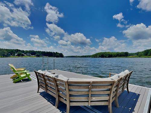 a dock with two chairs and a table on the water at Paravel in Swanton