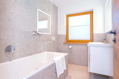 a bathroom with a bath tub and a window at Ferienwohnung Dorfmitte in Reit im Winkl