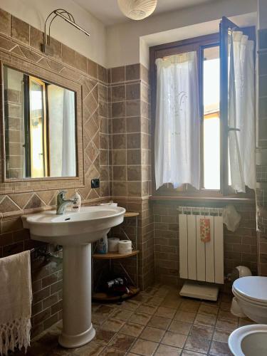 a bathroom with a sink and a toilet and a mirror at Casa dei nonni in Rigali