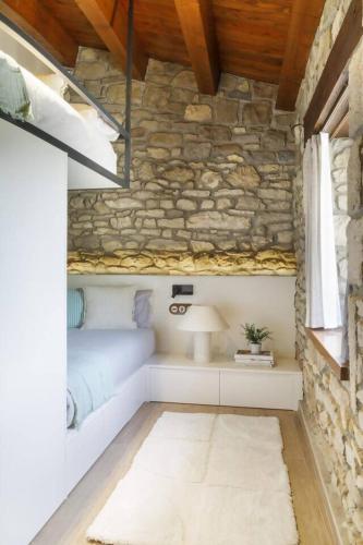 a room with a stone wall with a lamp and a rug at Villa Mas Summit in Collsuspina