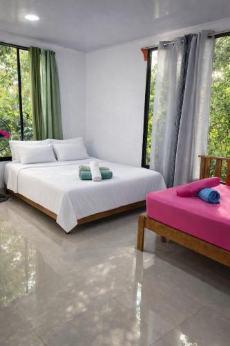 a bedroom with a large bed and two chairs at Mayra Campground in Savegre