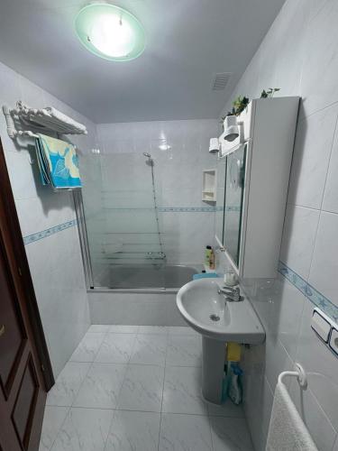 a white bathroom with a shower and a sink at Apartamento La Ojerada in Ajo