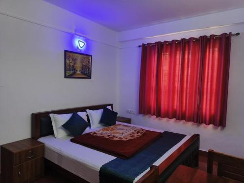 a bedroom with a bed with a red curtain at Rose Cottage in Devikolam