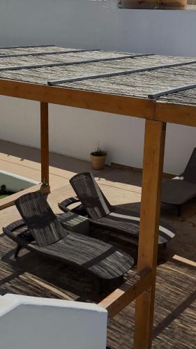 two chairs sitting under a table on a patio at Coralli Beach Hotel in Kokkini Khanion