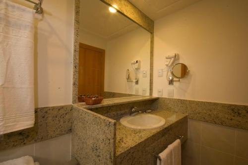 a bathroom with a sink and a mirror at Hotel Atlântico Business Centro in Rio de Janeiro