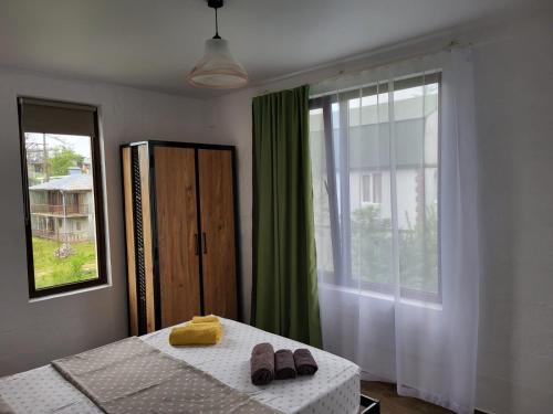 a bedroom with a bed with two slippers on it at Torgai Hotel Apartments in Ureki