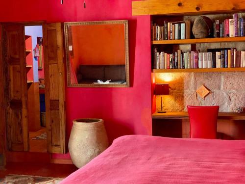 a bedroom with a pink wall with a bed and a mirror at Posada de la Cruz#5 in Querétaro