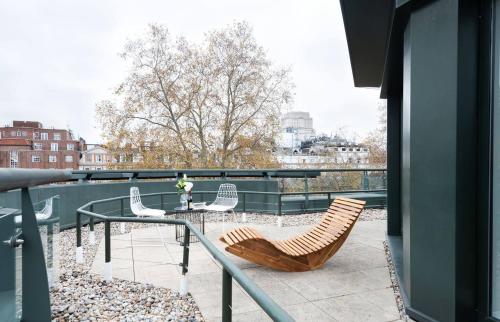 a patio with chairs and a table on a balcony at Oxford Street Fitzrovia Apartments by DMONTRIO in London