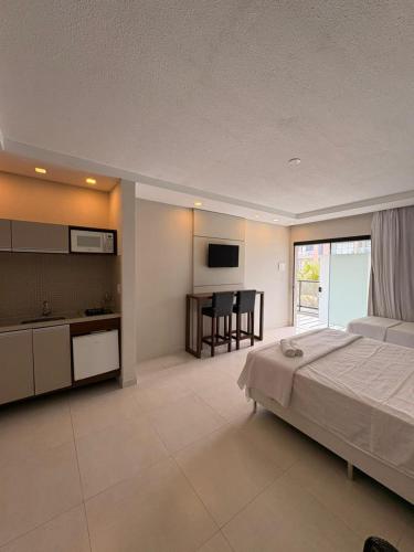 a bedroom with a bed and a kitchen and a table at Pousada São Gerônimo in Matinhos
