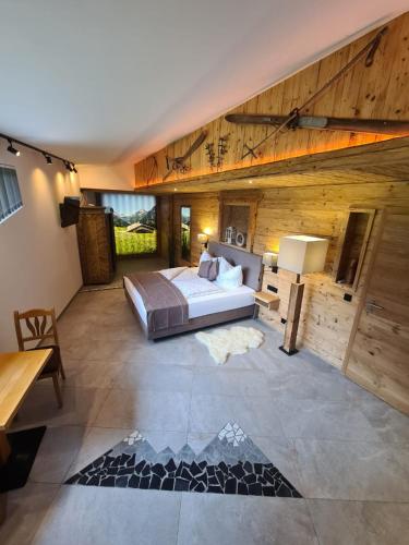 a bedroom with a bed in a room with wooden walls at Wellness Chalet Apartment Hochkalter in Bischofswiesen