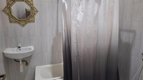 a bathroom with a shower curtain and a sink at Green Oasis in Nungwi