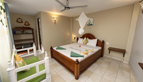 a small bedroom with a bed and a chair at Green Oasis in Nungwi
