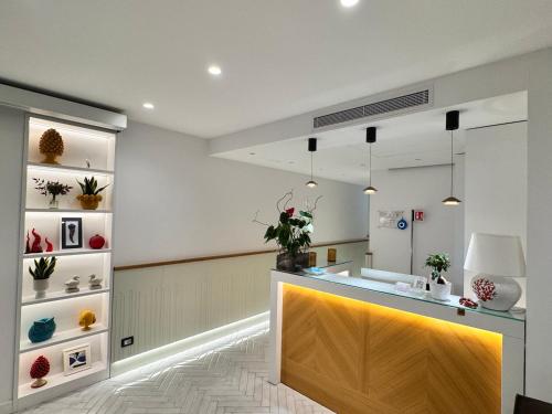 a kitchen with a counter with plants on shelves at Gioì Hotel Sorrento in Piano di Sorrento