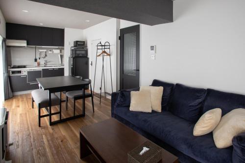 a living room with a blue couch and a kitchen at NIYS apartments 56type in Tokyo