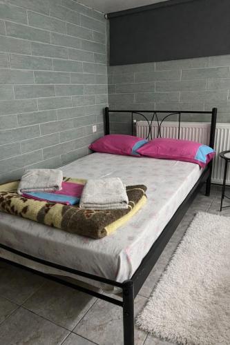 a bed with pink pillows and a blanket on it at Antonioy Apartment Kalampaka in Kalabaka