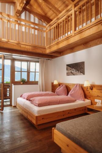 a bedroom with two beds in a room with wooden ceilings at Jausenstation Pfefferbauer in Zell am See