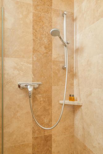 a shower with a shower head in a bathroom at Jausenstation Pfefferbauer in Zell am See