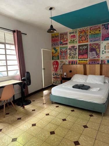 a bedroom with a bed with posters on the wall at La Palmera Hostel in Cali