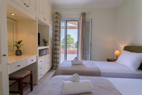 a bedroom with two beds and a balcony at Villa Olympic Azure with Private Pool in Dassia