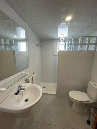 a white bathroom with a sink and a toilet at Apartamento Terraza Mar in Malgrat de Mar