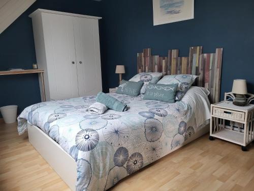 a bedroom with a bed with blue walls at L'Oustaou du Bodo in Ambon