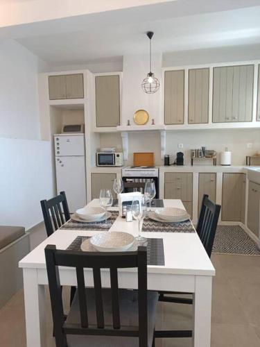 a kitchen with a white table with chairs and a white tableablish at Terpsithea in Triandáros