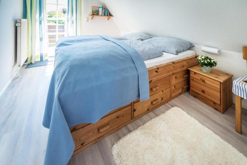a bedroom with a bed with a blue comforter at Das Sonnenhaus in Lindaunis
