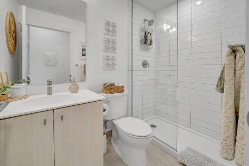 a white bathroom with a toilet and a shower at Propercare - The Wellingtons in Kitchener
