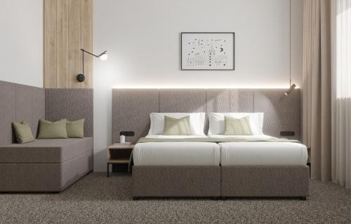 ein Schlafzimmer mit einem großen Bett und einer Couch in der Unterkunft Hotel Siscia in Sisak