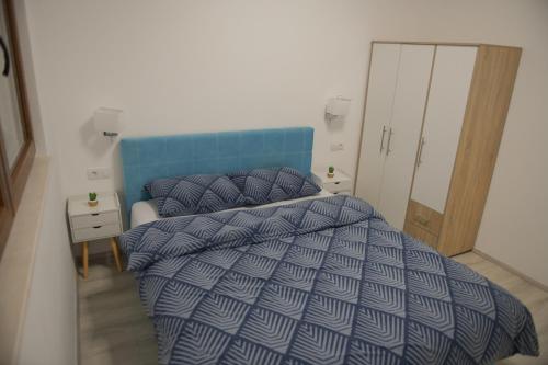 a bedroom with a bed with a blue and white comforter at Villa Panorama - Private heated pool and jacuzzi with ocean view in Ivanica