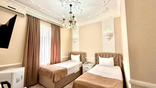 a room with two beds and a chandelier at Hotel B&S Samarkand Boutique in Samarkand