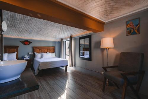 a bedroom with a bed and a tub in a room at Casa Xaca in San Miguel de Allende