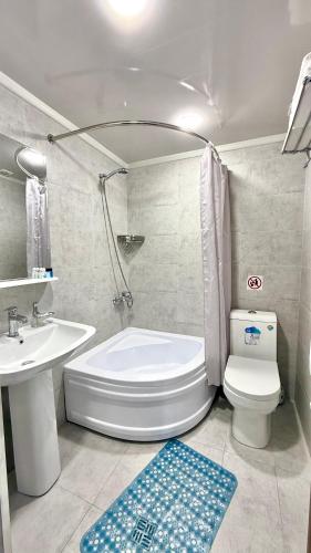 a bathroom with a toilet and a tub and a sink at Hotel B&S Samarkand Boutique in Samarkand