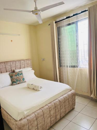 a bed in a room with a large window at Figtree 1bedroom by kiv in Kilifi