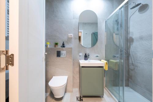 a bathroom with a toilet and a sink and a shower at Fratello Apartment in Podgorica